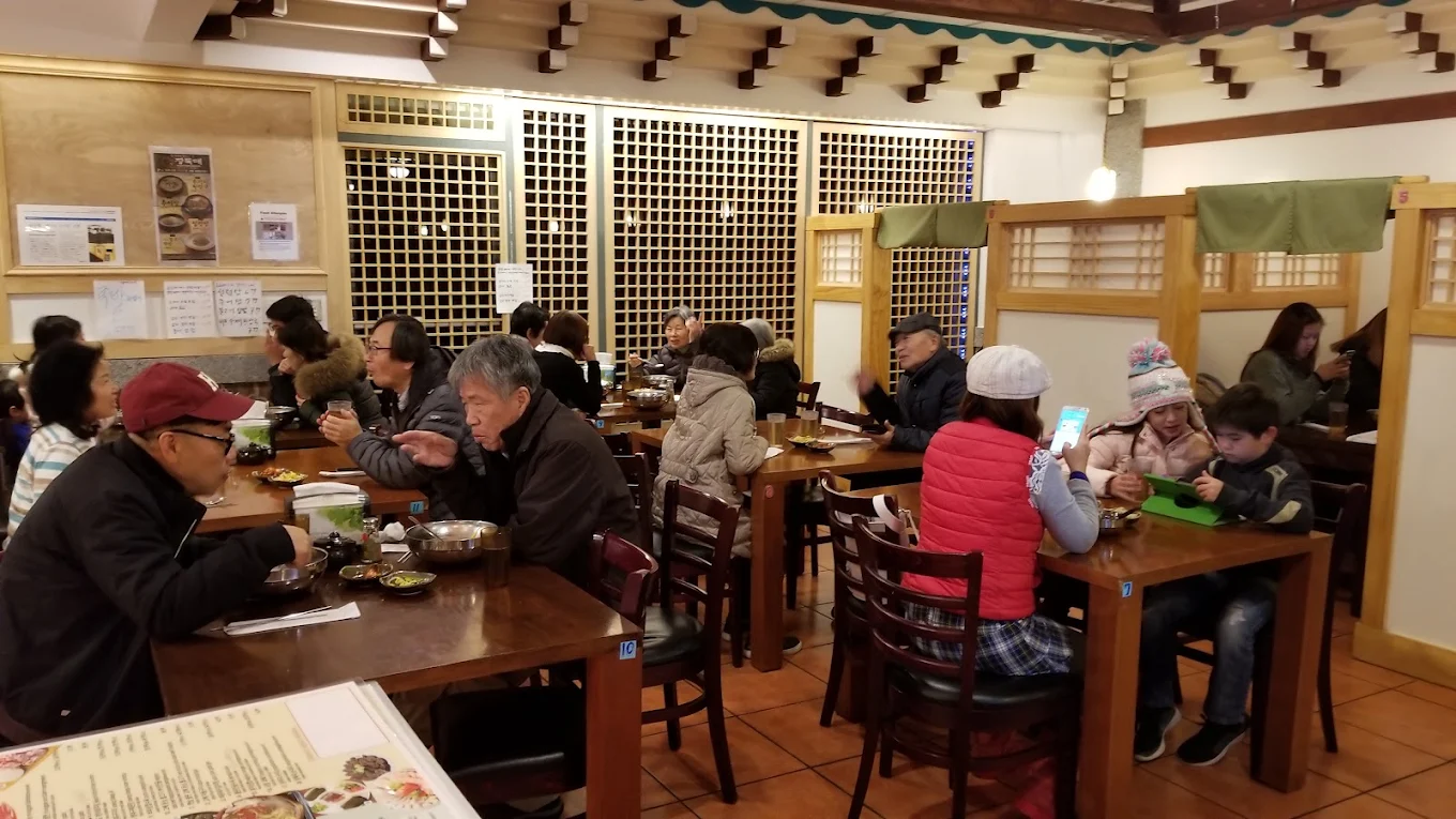 A busy evening in the Jang Dok Dae dining room, families sharing meals across full tables